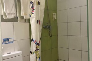 A bathroom with a toilet, a shower with a green tiled wall, and a curtain with a colorful leaf pattern. - 100 Inn Shanghai Songjiang Xincheng Subway Station (Shanghai)