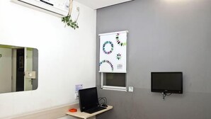 A room with a bed, a desk with a laptop, a TV, and a wall-mounted air conditioning unit. - 100 Inn Shanghai Songjiang Xincheng Subway Station (Shanghai)