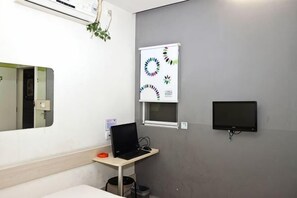 A room with a bed, a desk with a laptop, a TV, and a wall-mounted air conditioning unit. - 100 Inn Shanghai Songjiang Xincheng Subway Station (Shanghai)