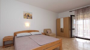 A bedroom with a wooden bed, a nightstand, a chair, a wardrobe, and a window with curtains. - ROSANNA 2 Studio with Balcony (Rovinj)