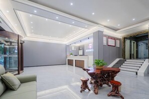 A modern lobby with a reception desk, a staircase, and a seating area. - City 118 Express Hotel (Penglai Scenic Area Bathing Beach Branch) (Yantai)