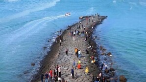 A rocky shoreline with people gathered along it, some standing and others sitting. - City 118 Express Hotel (Penglai Scenic Area Bathing Beach Branch) (Yantai)