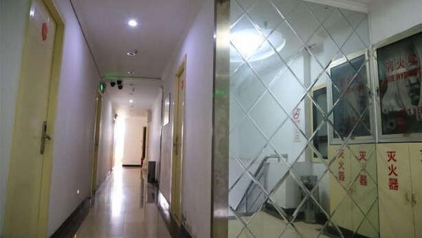 A hallway with a glass partition, a staircase, and a door with a red sign. - Haoting hotel (Shanghai Xincun Road Subway Station) (Shanghai)