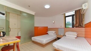 A hotel room with two single beds, a desk with a chair, and a window with curtains. - Haoting hotel (Shanghai Xincun Road Subway Station) (Shanghai)