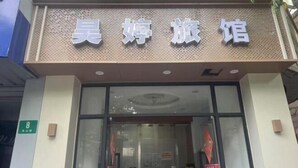 A hotel entrance with a sign reading "吴婷旅馆" and a green sign indicating room number 8. - Haoting hotel (Shanghai Xincun Road Subway Station) (Shanghai)