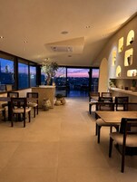 A modern dining area with a view of the cityscape at dusk.