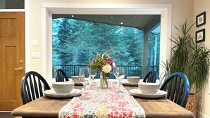 A dining table set with white plates, bowls, and glasses, covered by a floral tablecloth.