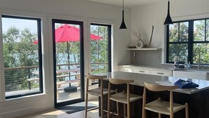 A modern kitchen with a large island, bar stools, and pendant lighting.