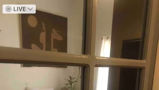 Une chambre à coucher avec un lit, des oreillers, une table de chevet et une œuvre d’art murale.