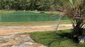 A stone patio with a view of a lake and trees. - Charming 2-bedroom RV with WiFi and AC in peaceful Silverhill Alabama (Silverhill)