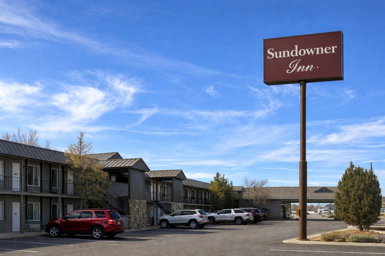 A Sundowner Inn with a parking lot and a clear blue sky.