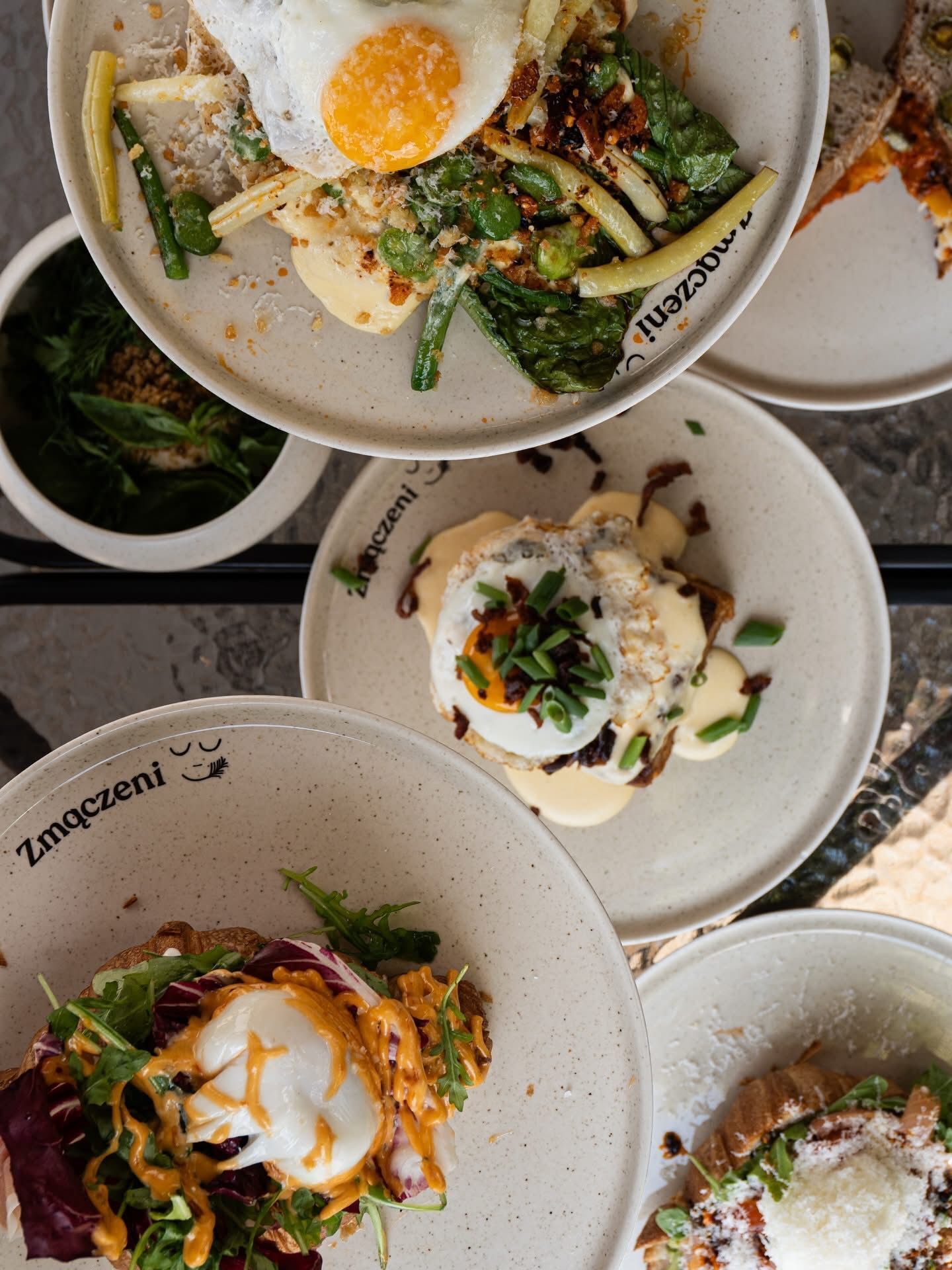 A dining table with multiple plates of food, including eggs and salads.