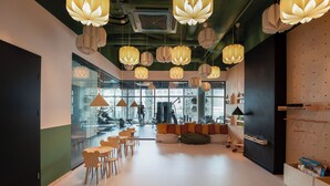 A modern interior with hanging paper lanterns, a seating area with bean bags, and a view of the city through large windows. - Apartament Tower by Kairos Apartments (Katowice)