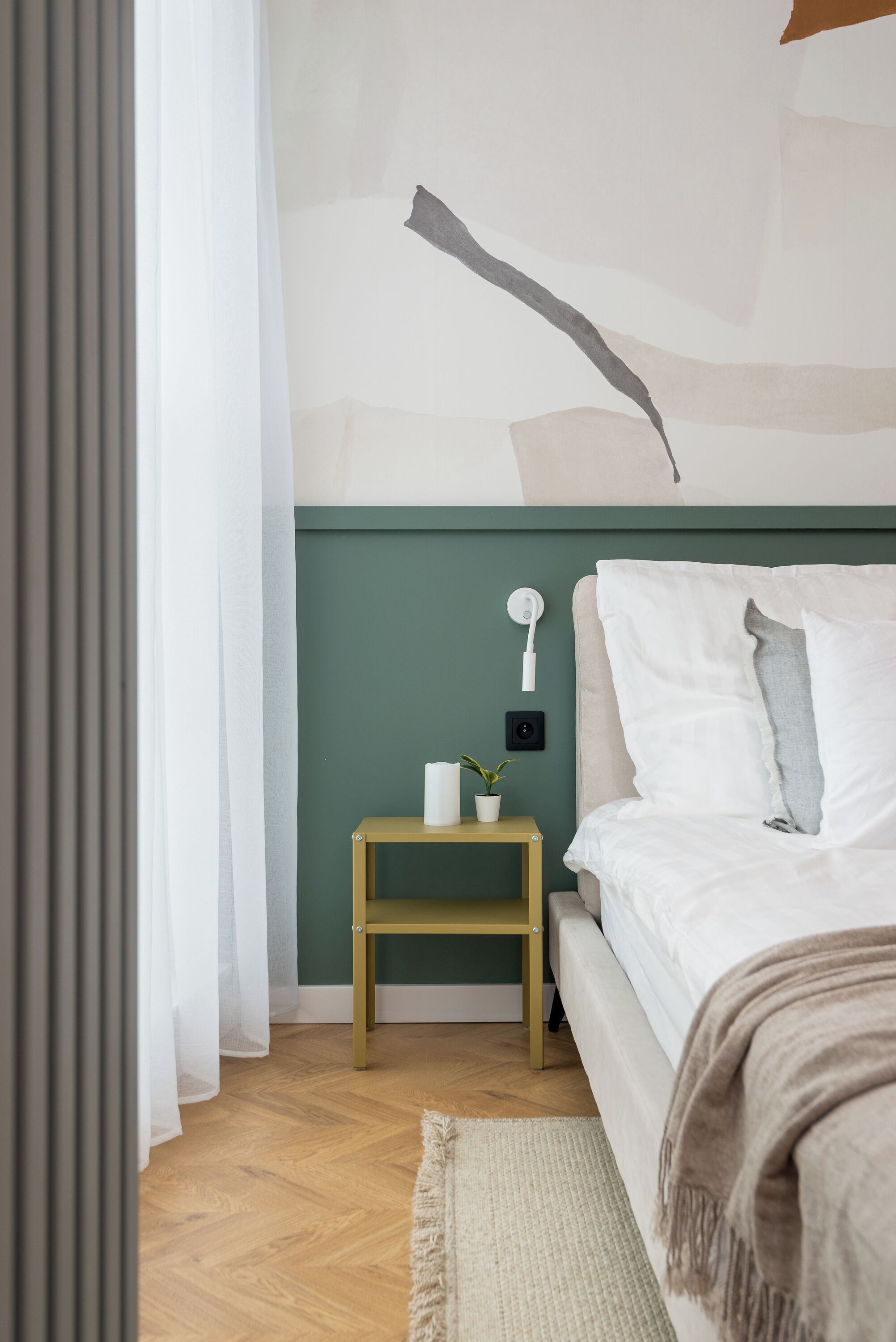 Une chambre à coucher avec un lit, une table de chevet et un luminaire fixé au mur.