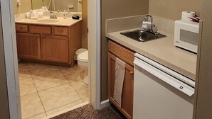 Een kleine badkamer met een wastafel, toilet en spiegelkast.