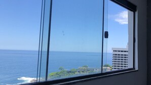 Vista a través de una ventana con cielo despejado y océano.