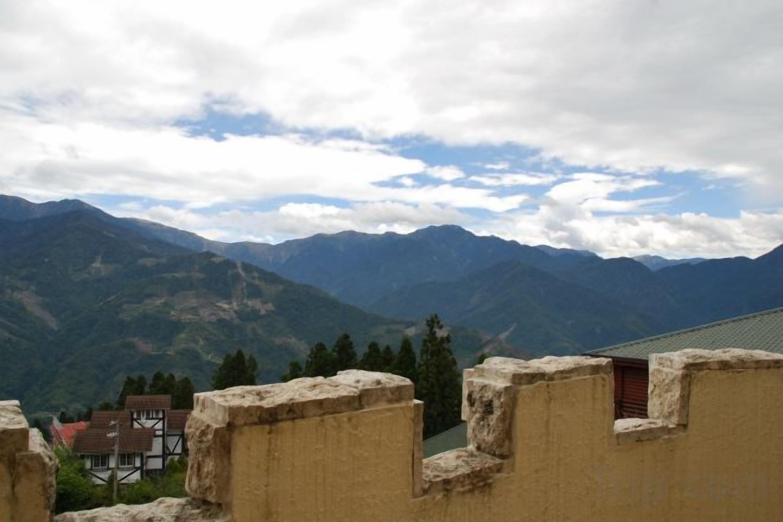 Eine gebirgige Landschaft mit einem Gebäude, das Steinmauern und ein kleines Fenster hat.