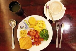 A plate of food with a cup and cutlery on a wooden table. - Huis Ten Bosch (Nantou)