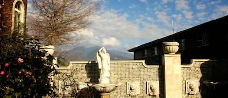 Un patio con una fuente, paredes con azulejos y una estatua.
