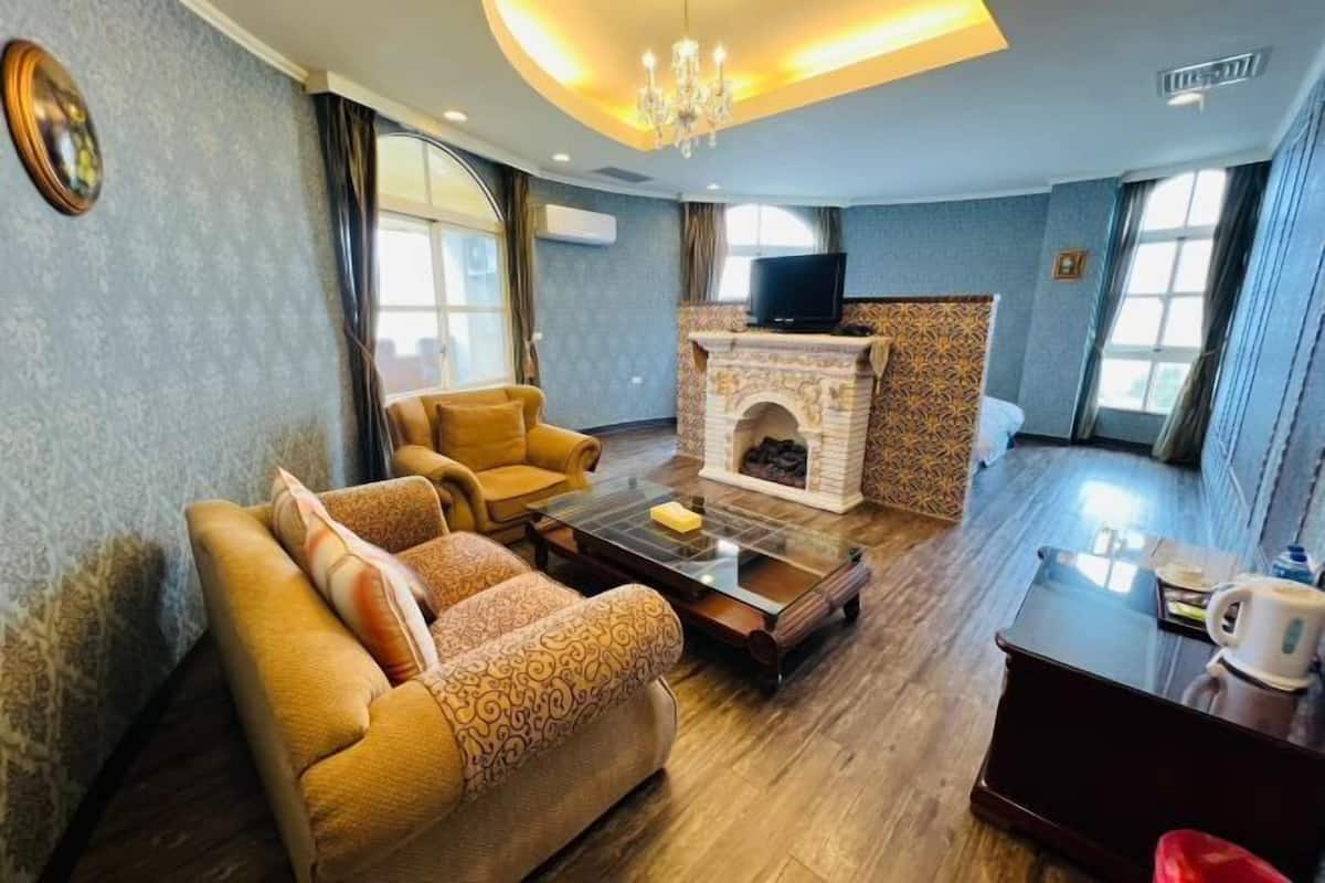 Una sala de estar con un sofá, una chimenea, un televisor y una mesa de centro.