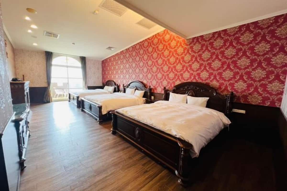 Habitación de hotel con dos camas, piso de madera y pared con diseño rojo.
