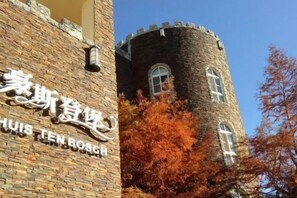 A brick building with a tower and a sign that reads 'Huis Ten Bosch.' - Huis Ten Bosch (Nantou)