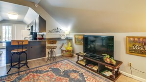 Une cuisine moderne avec un coin repas, un téléviseur et un tapis décoratif.