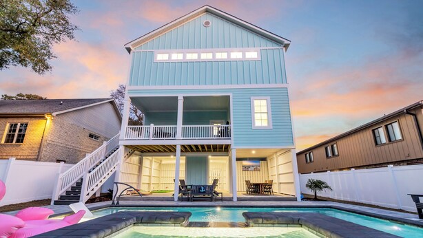 Une maison à deux étages dotée d’un balcon, d’une piscine et d’un escalier menant à l’étage supérieur.