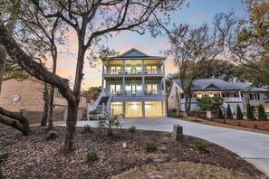 A two-story house with a front porch, a driveway, and a landscaped yard.