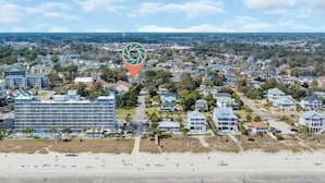 Un hôtel situé sur la côte, composé de plusieurs bâtiments, avec une plage et une vue dégagée sur l’océan.