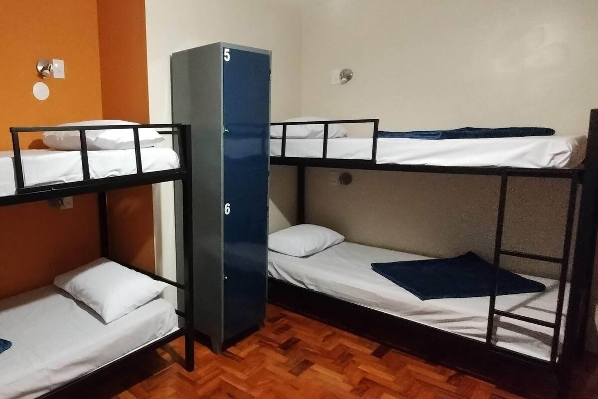 Ein Schlafzimmer mit Etagenbetten, einem Kleiderschrank und einer Steckdose.