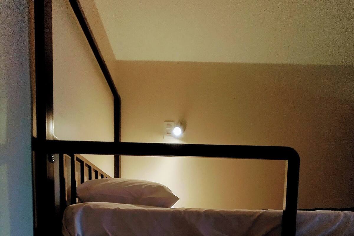 Ein Stockbett mit einer Leuchte darüber.