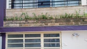 A building with a garage door labeled 'Soul,' a balcony with metal railings, and a stone facade. - Soul Hostel 2 (Sao Paulo)