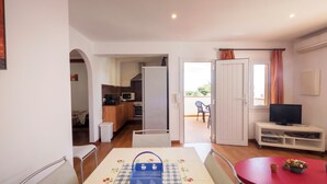 A compact living space with a dining area, kitchenette, and a balcony. - Llevant 11 E1 (Cap d'Artrutx)