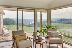 Un balcon avec deux chaises, une petite table et des plantes en pot.