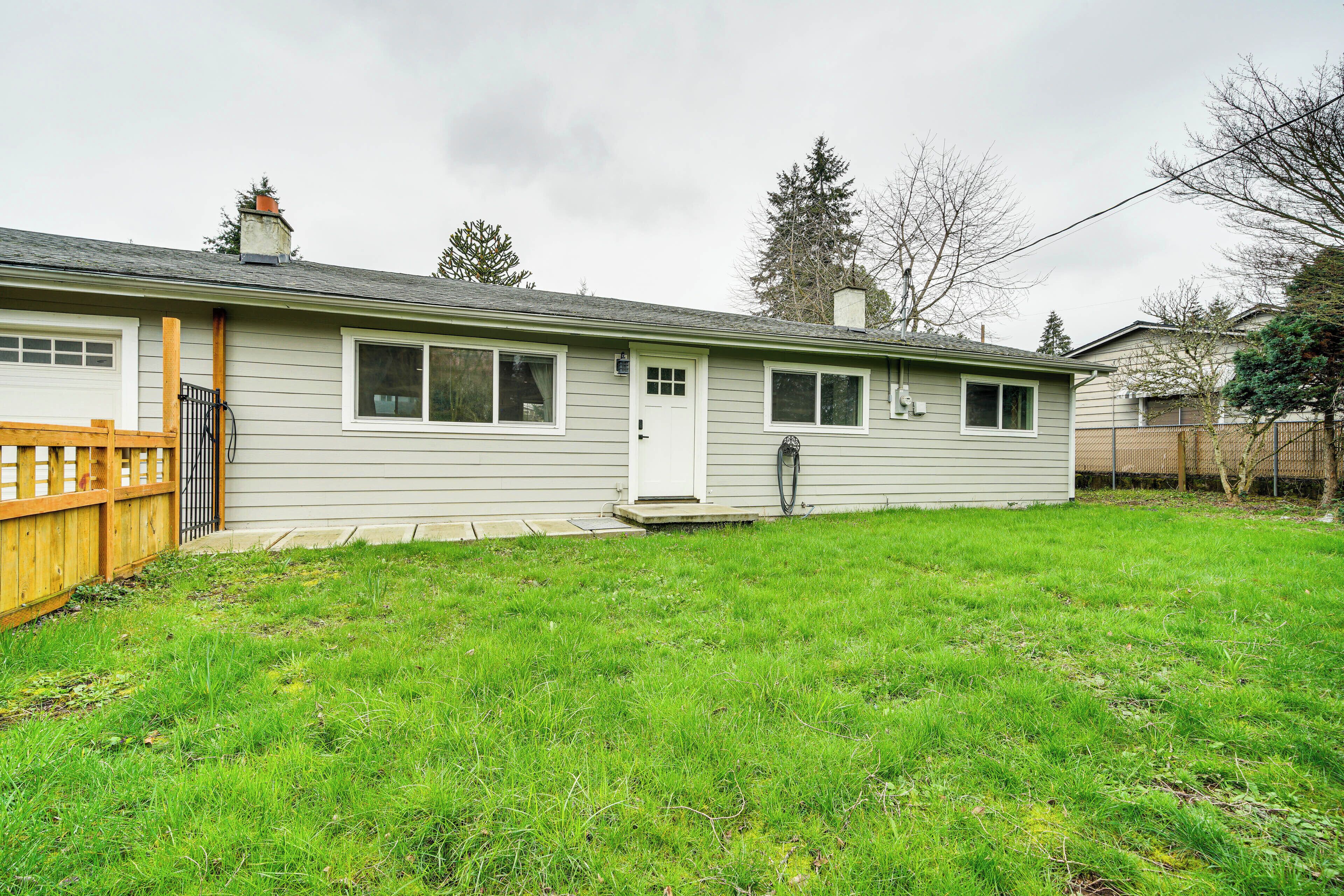 A single-story house with a front door, a small porch, and a fenced yard.