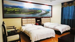 A hotel room with two beds, a large painting of a landscape, a chair, and a wooden floor.