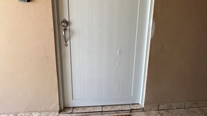 A white door with a keyhole and a doorbell. - Vista Ramey Apartment (Aguadilla)