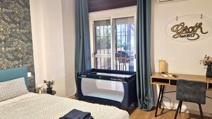A hotel room with a bed, a desk, a pool table, and a window with curtains.