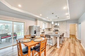 A modern kitchen with a dining area, large windows, and a view of the outdoors. - 3 Mi to Dtwn: Family-Friendly Home in South Haven! (South Haven)