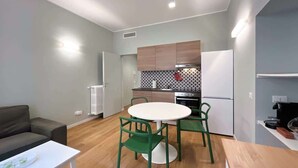 Une cuisine moderne avec un coin repas comprenant une table ronde et des chaises, un canapé et un radiateur.