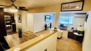 A modern living area with a kitchen, dining space, and a seating area.