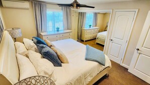 A hotel room with a large bed, bedside tables, a wardrobe, and a ceiling fan.