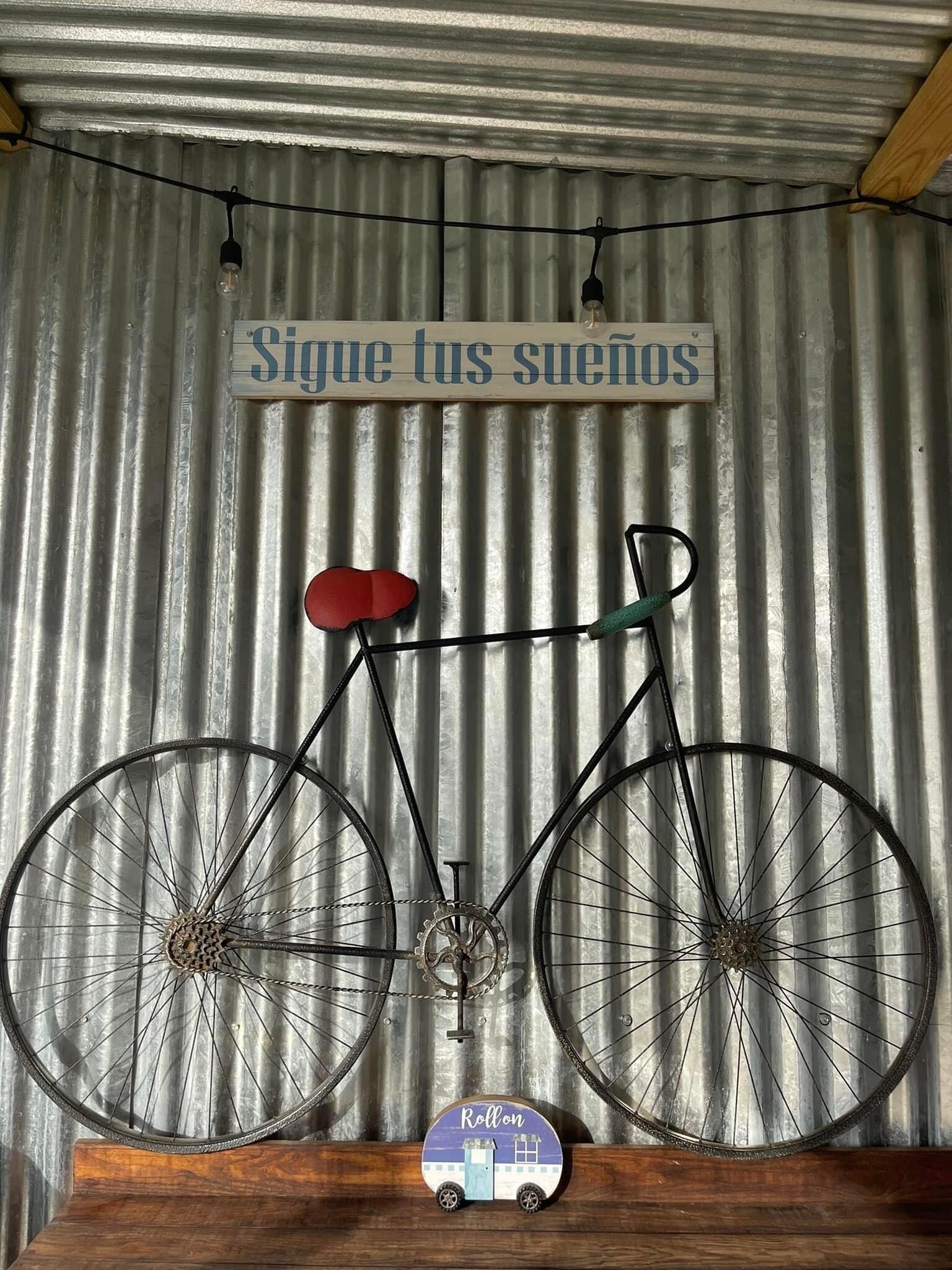 Een fiets met een rood zadel en een klein houten bordje eronder met de tekst 'Rollon'.