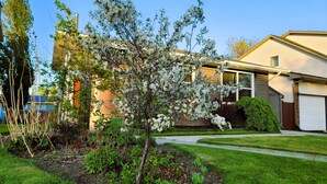 A residential house with a well-maintained garden, a driveway, and a garage.