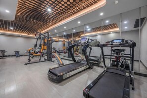 Ein Fitnessraum mit Laufbändern, einem Ergometer und Krafttrainingsgeräten.