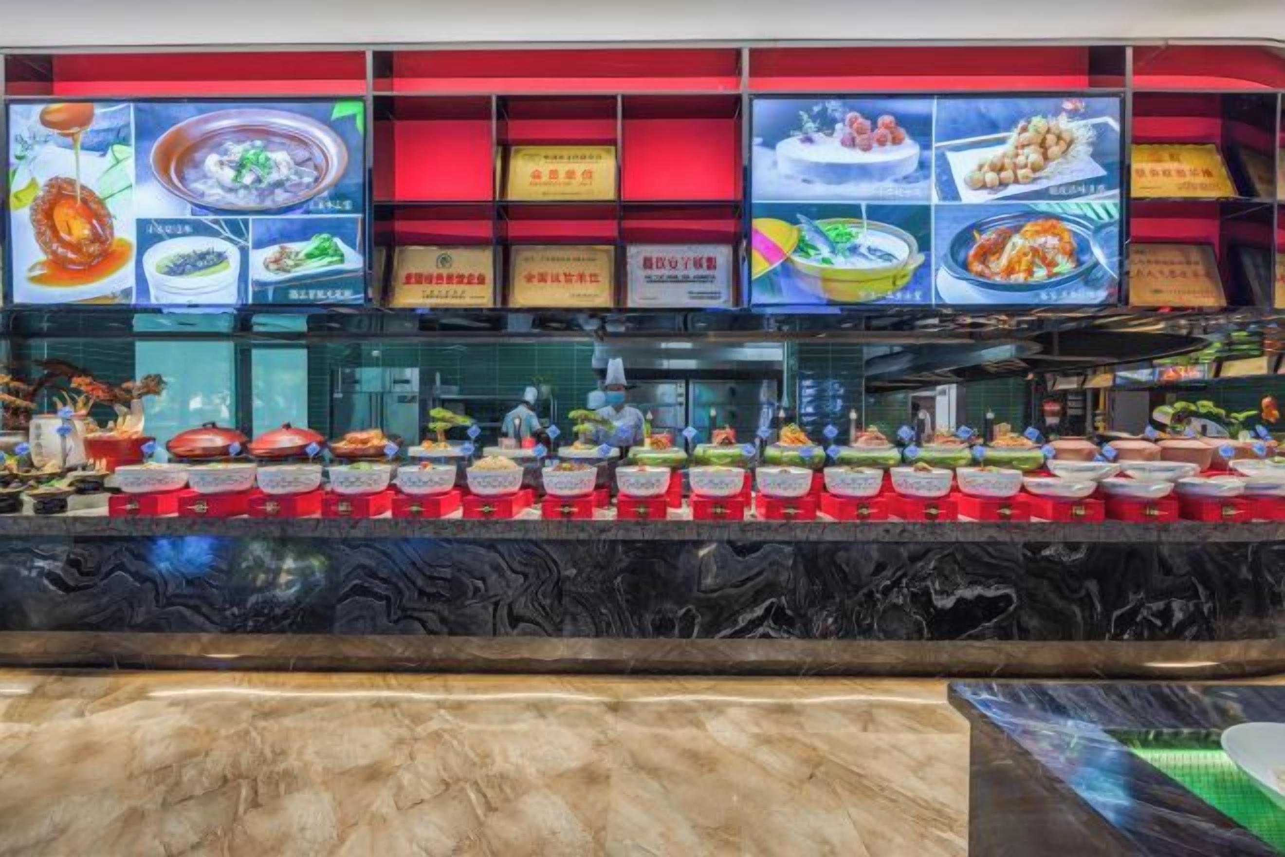 A buffet area with multiple food stations and a digital menu display.