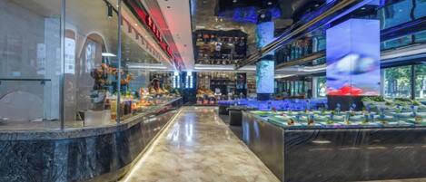 A modern interior with a curved counter, a fish display, and a ceiling with a digital screen.