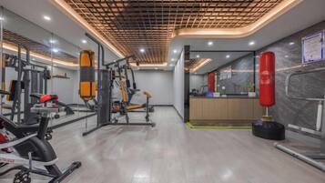 A gym with exercise equipment, a punching bag, and a mirror.