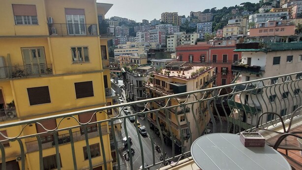 A balcony with a view of a cityscape, featuring multi-story buildings and a street below. - Domus Schipa (Naples)